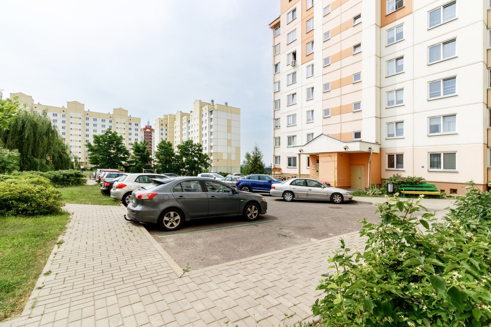 cars in front of a condo building.