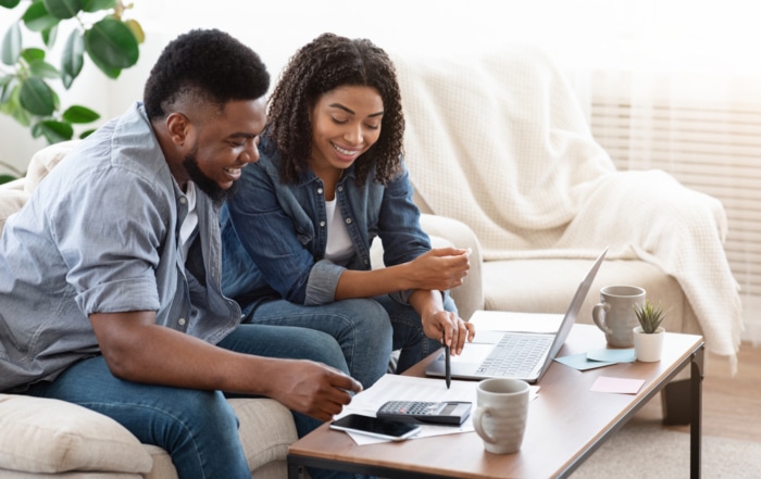 black couple is poring over their finances and thinking about a credit card balance transfer