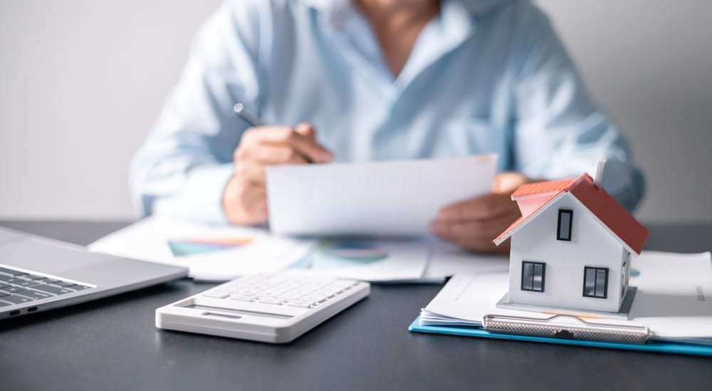 person filling out forms relating to paying the mortgage and doing their budget