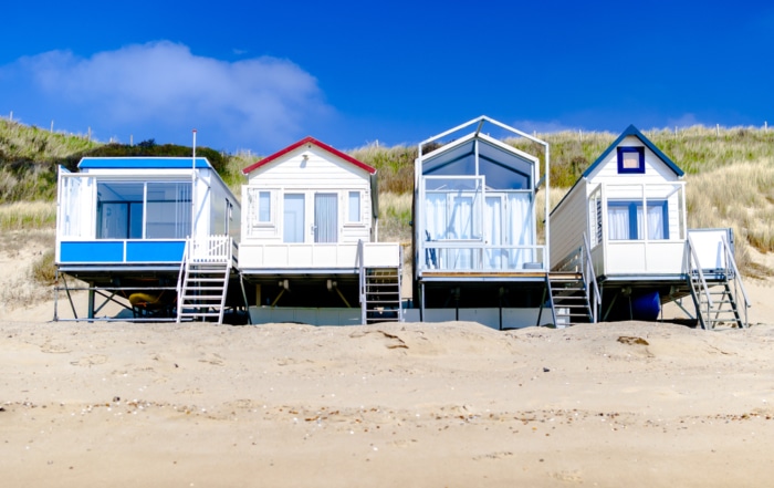 Four beach houses on a white sand beach